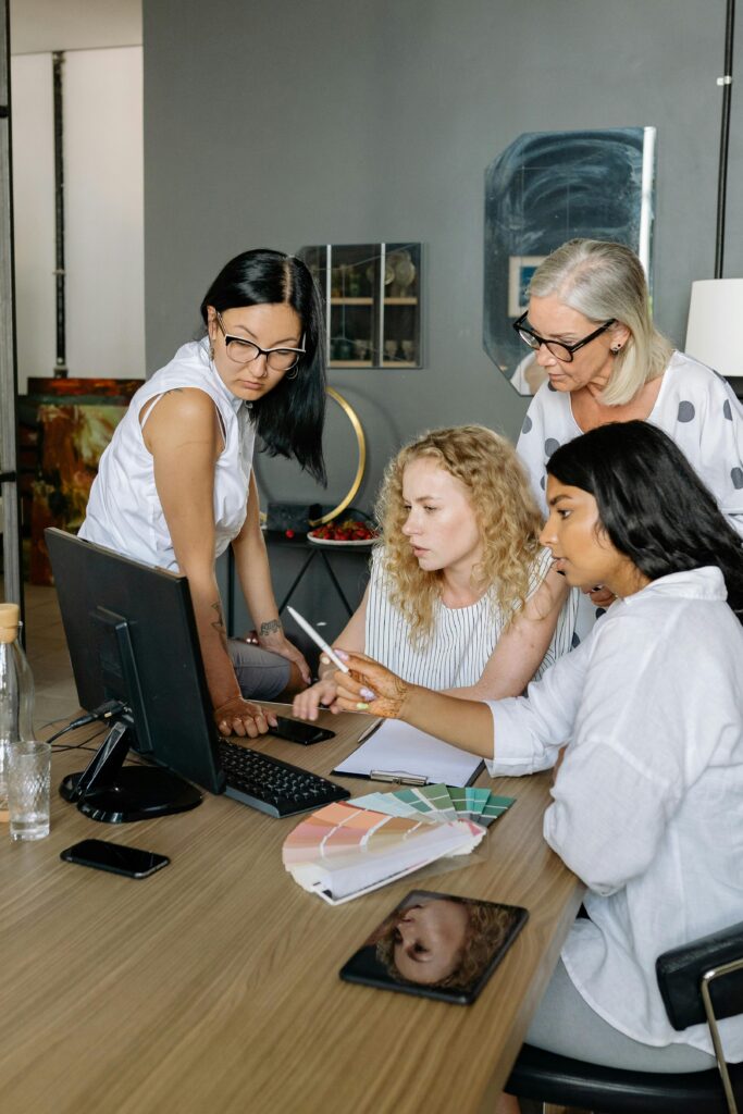 4 girls looking at computer screen and discussing